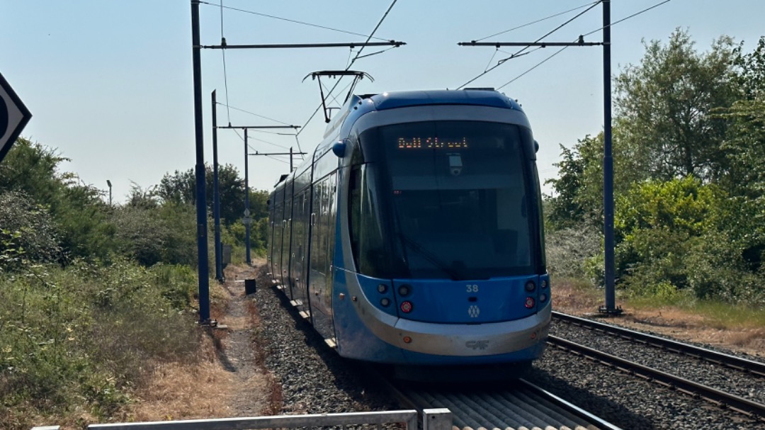 Jamie Lee Bench on Train Siding: West Midlands Metro CAF Urbos 100 departs away from Wednesbury Great Western Street heading towards Birmingham 10/6/23