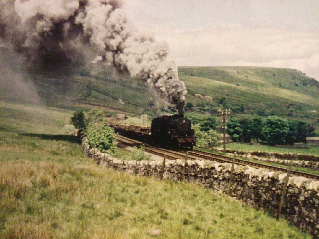 Alex Coomber on Train Siding: An ex LMS Hughes Crab 2-6-0 raises a pall of smoke over the Pennine fells as it struggles up to the summit of the line at Ais Gill
with a...