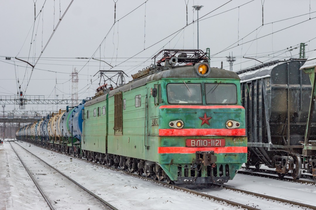 CHS200-011 on Train Siding: The electric locomotive VL10-1121, a few months before utilisation, is traveling to the Volkhvovstroy-1 station with a liquid cargo
train