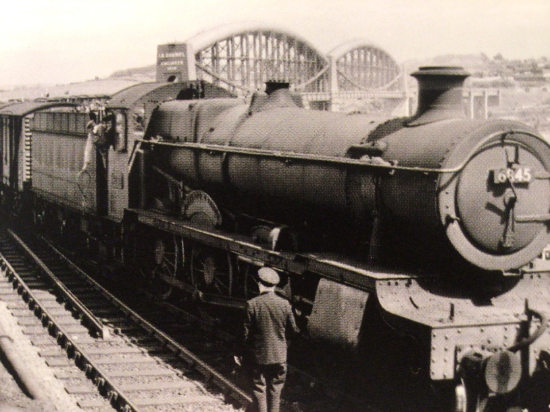 Alex Coomber on Train Siding: Heading a down goods train from Plymouth to Cornwall. A Grange Class 4-6-0 No. 6845 Paviland Grange halts at Saltash for the
driver to...