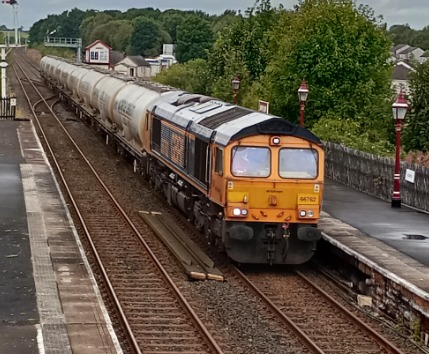 Hardley Distant on Train Siding: CURRENT: 66762 passes through Appleby Station today with the 4N03 11:25 Carlisle New Yard to Clitheroe Castle Cement service.