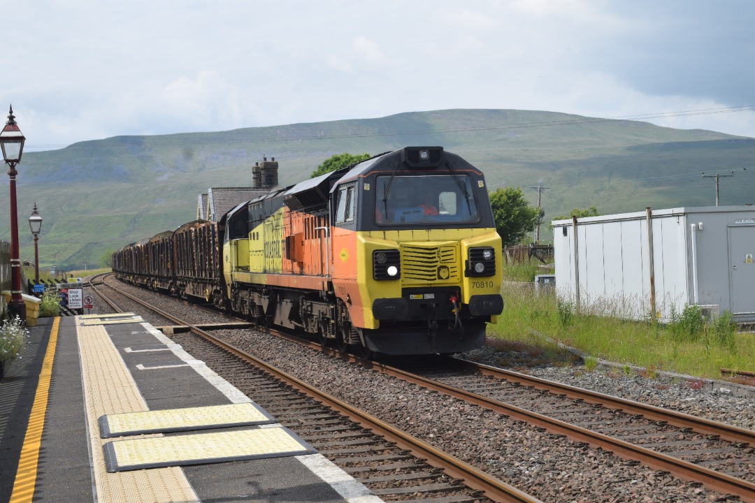 Hardley Distant on Train Siding: CURRENT: 70810 passes through Robblehead Station today with the 6J37 12:52 Carlisle Yard to Chirk Kronospan Logs service.