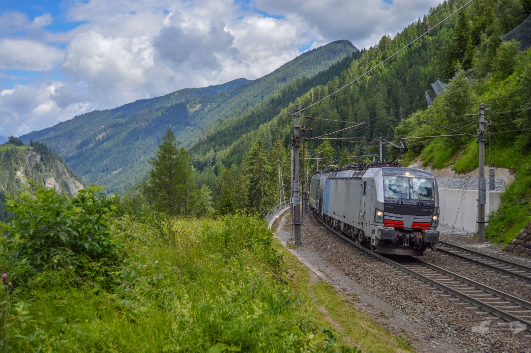 Adam L. on Train Siding: An Railpool Vectron coupled with an Beacon Rail (Ex - MRCE) Eurosprinter are seen climbing the grade towards Brenner Pass with an long
and...