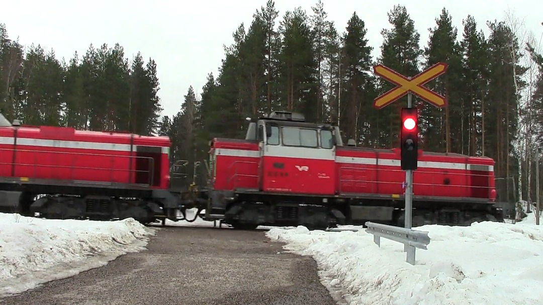 Trains & level crossings from Finland on Train Siding: Freight train T 2858 passes Kalliojärvenkatu level crossing in Heinola, Finland 28.3.2021