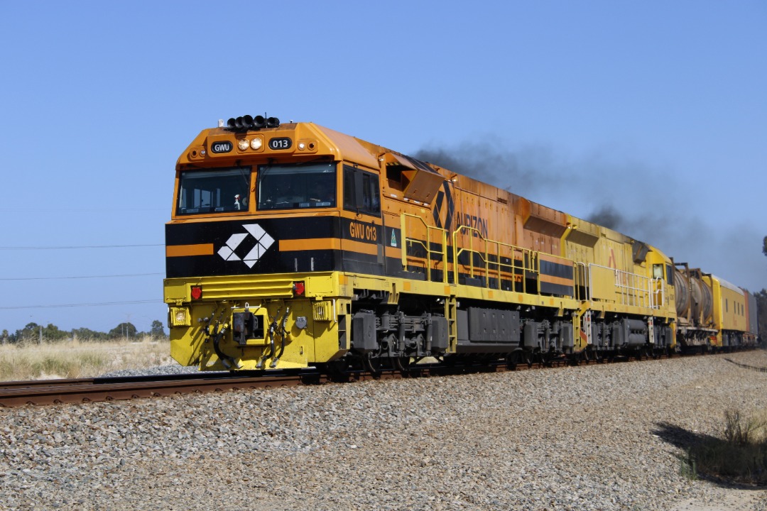 Gus Risbey on Train Siding: Aurizon's 5MP1 intermodal service is seen racing through Farrall rd level crossing, Stratton WA with locomotives GWU013 &
ACD6047 being...